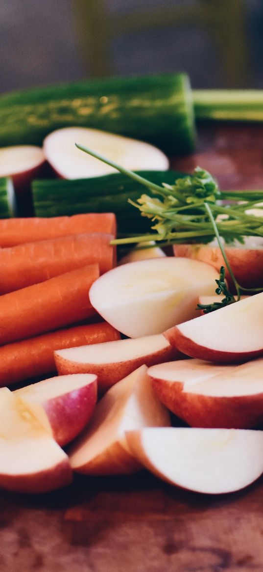 carrots, vegetables, parsley, cucumber, broccoli, apples, cutting board