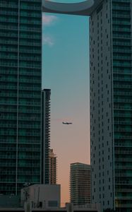 Preview wallpaper airplane, buildings, skyscrapers, evening