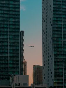 Preview wallpaper airplane, buildings, skyscrapers, evening
