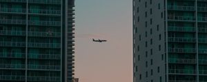 Preview wallpaper airplane, buildings, skyscrapers, evening