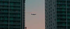 Preview wallpaper airplane, buildings, skyscrapers, evening