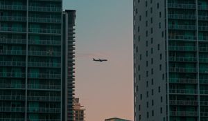 Preview wallpaper airplane, buildings, skyscrapers, evening