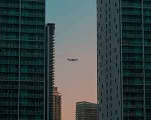 Preview wallpaper airplane, buildings, skyscrapers, evening