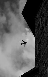 Preview wallpaper airplane, clouds, flight, building, black and white