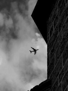 Preview wallpaper airplane, clouds, flight, building, black and white