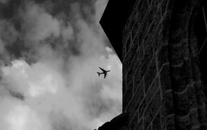 Preview wallpaper airplane, clouds, flight, building, black and white