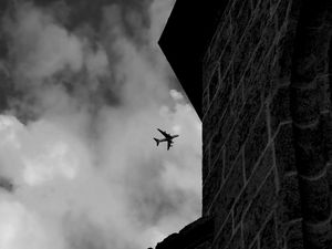 Preview wallpaper airplane, clouds, flight, building, black and white