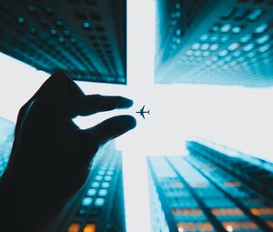 Preview wallpaper airplane, hand, buildings, sky, skyscrapers