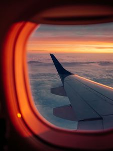 Preview wallpaper airplane, porthole, wing, sunset, clouds, sky