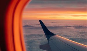 Preview wallpaper airplane, porthole, wing, sunset, clouds, sky