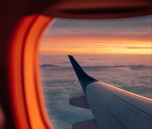 Preview wallpaper airplane, porthole, wing, sunset, clouds, sky