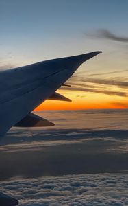 Preview wallpaper airplane, wing, clouds, flight, sky, sunset, dawn