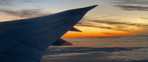 Preview wallpaper airplane, wing, clouds, flight, sky, sunset, dawn