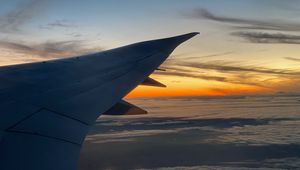 Preview wallpaper airplane, wing, clouds, flight, sky, sunset, dawn