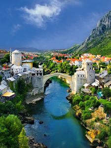 Preview wallpaper alpine, town, mountains, houses, bridge, river, trees, nature, landscape