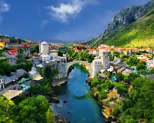 Preview wallpaper alpine, town, mountains, houses, bridge, river, trees, nature, landscape