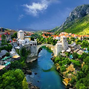 Preview wallpaper alpine, town, mountains, houses, bridge, river, trees, nature, landscape