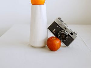 Preview wallpaper apple, orange, camera, vase, branch, decor