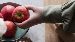 Preview wallpaper apples, fruit, hand, flowers