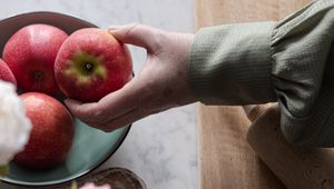 Preview wallpaper apples, fruit, hand, flowers