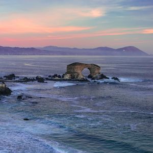 Preview wallpaper arch, rocks, sea, waves, sunset