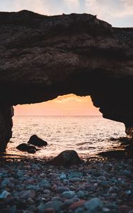 Preview wallpaper arch, stones, pebbles, sea, coast, sunset