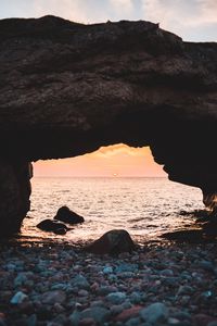 Preview wallpaper arch, stones, pebbles, sea, coast, sunset