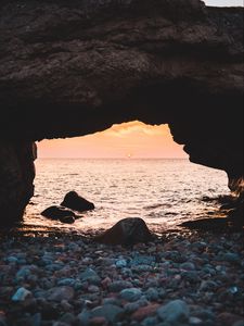 Preview wallpaper arch, stones, pebbles, sea, coast, sunset