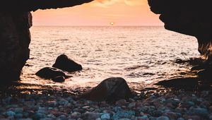 Preview wallpaper arch, stones, pebbles, sea, coast, sunset