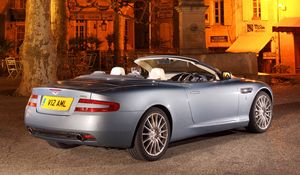 Preview wallpaper aston martin, db9, 2004, blue, side view, style, sports, car, street, house, monument, tree, lamp
