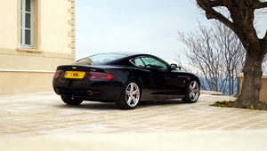 Preview wallpaper aston martin, db9, 2006, black, side view, style, sports, auto, building, tree, sky