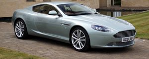 Preview wallpaper aston martin, db9, 2010, blue metallic, side view, style, sports, auto, building, grass