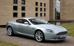 Preview wallpaper aston martin, db9, 2010, blue metallic, side view, style, sports, auto, building, grass