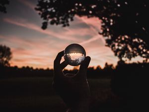 Preview wallpaper ball, glass, hand, sunset, transparent