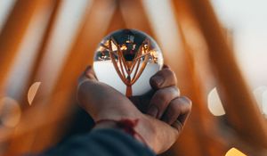 Preview wallpaper ball, glass, hand, reflection, blur