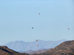 Preview wallpaper balloons, mountains, rocks, flight, sky