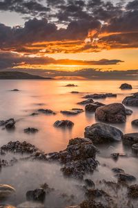 Preview wallpaper bay, sunset, horizon, stones, clouds