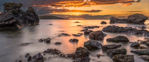 Preview wallpaper bay, sunset, horizon, stones, clouds