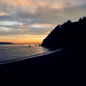 Preview wallpaper beach, mountains, sea, sunset, silhouettes, dark