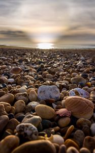 Preview wallpaper beach, pebbles, sea, stones, sky, rays