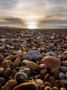 Preview wallpaper beach, pebbles, sea, stones, sky, rays