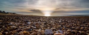 Preview wallpaper beach, pebbles, sea, stones, sky, rays