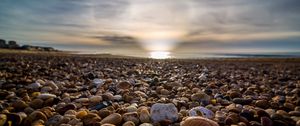 Preview wallpaper beach, pebbles, sea, stones, sky, rays