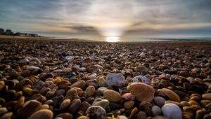 Preview wallpaper beach, pebbles, sea, stones, sky, rays