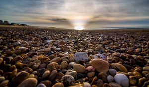 Preview wallpaper beach, pebbles, sea, stones, sky, rays