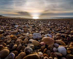 Preview wallpaper beach, pebbles, sea, stones, sky, rays