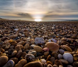 Preview wallpaper beach, pebbles, sea, stones, sky, rays