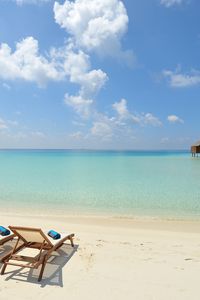 Preview wallpaper beach, sand, chairs, resort, sky, clouds, bungalow, huts, blue, clearly, horizon, relax