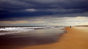 Preview wallpaper beach, sand, coast, ocean, person, loneliness, cloudy, emptiness