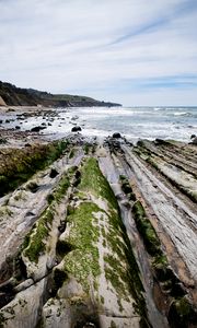 Preview wallpaper beach, stones, trees, mountains, sea, horizon, landscape